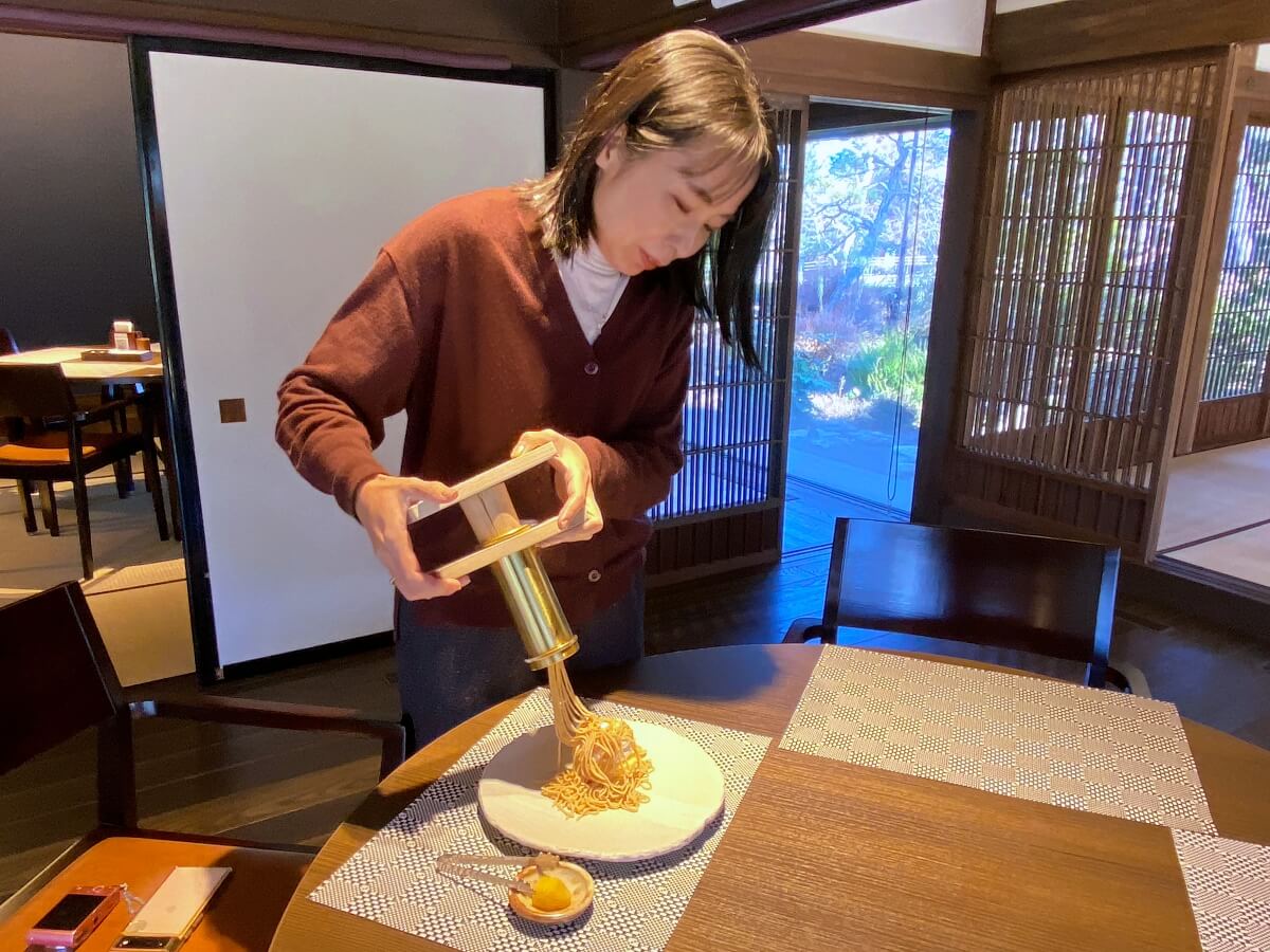 「古民家カフェ KONOHANA」でモンブランの餡を絞って盛り付ける体験をしている辛酸なめ子さん