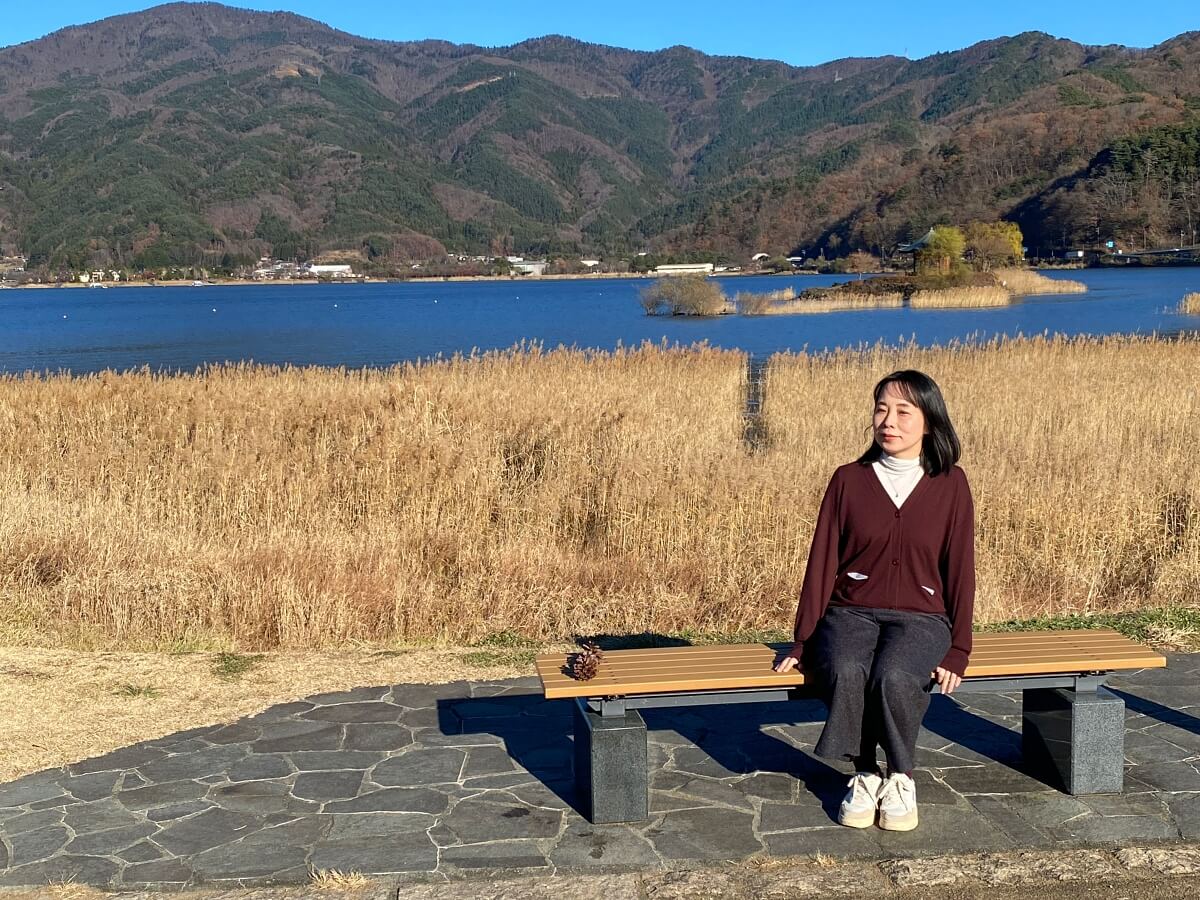 河口湖に面した八木崎公園のベンチに座る辛酸なめ子さん