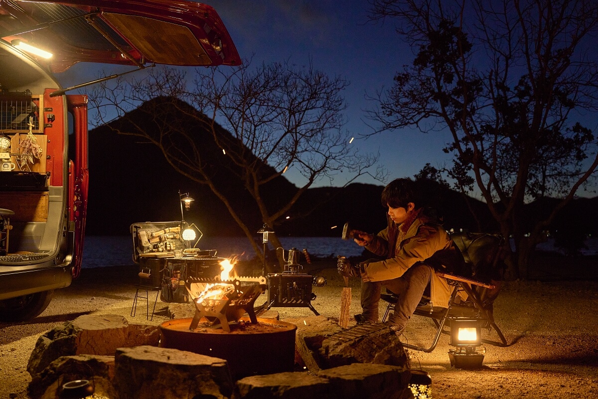 焚き火にくべる薪を割るジベキャンさん