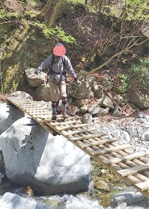 清流に架かった揺れる丸太橋を渡る