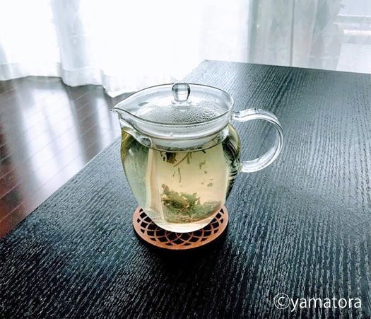 ガラスポットにハーブティーの茶葉を入れお湯を注ぐ