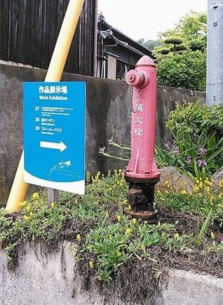 島内にある作品の案内看板と赤い消火栓