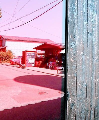 豊島横尾館の赤いガラスに映る対面の店