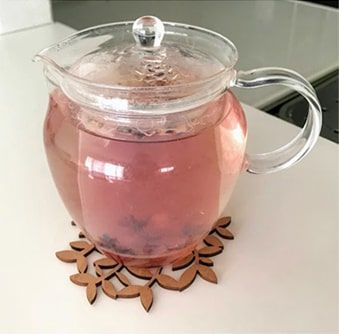 ハーブ茶葉を入れたガラスポットに熱湯を注ぐ