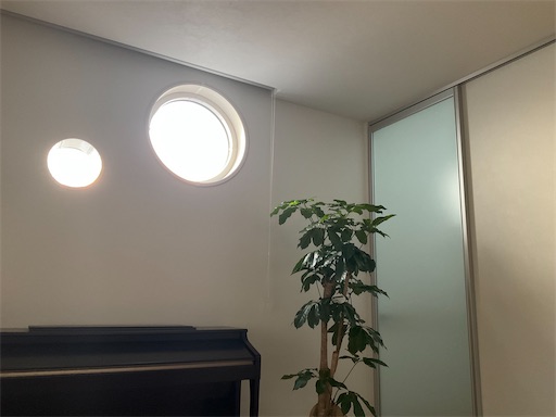 朝の時間帯の丸窓　朝日が反射して部屋に光が取り込まれている様子