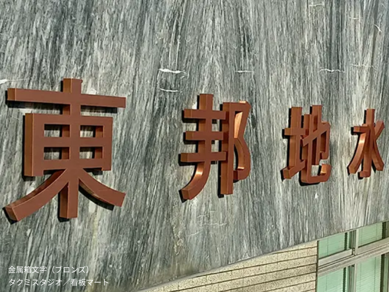 ブロンズ製の金属箱文字看板（チャンネルサイン）。重厚でアンティーク調の仕上がりが特徴。歴史ある建物や老舗店舗に最適。