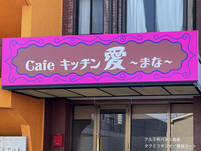 店舗入口に設置されたアルミ枠パネル看板。施設名や営業時間などの案内に適した看板。