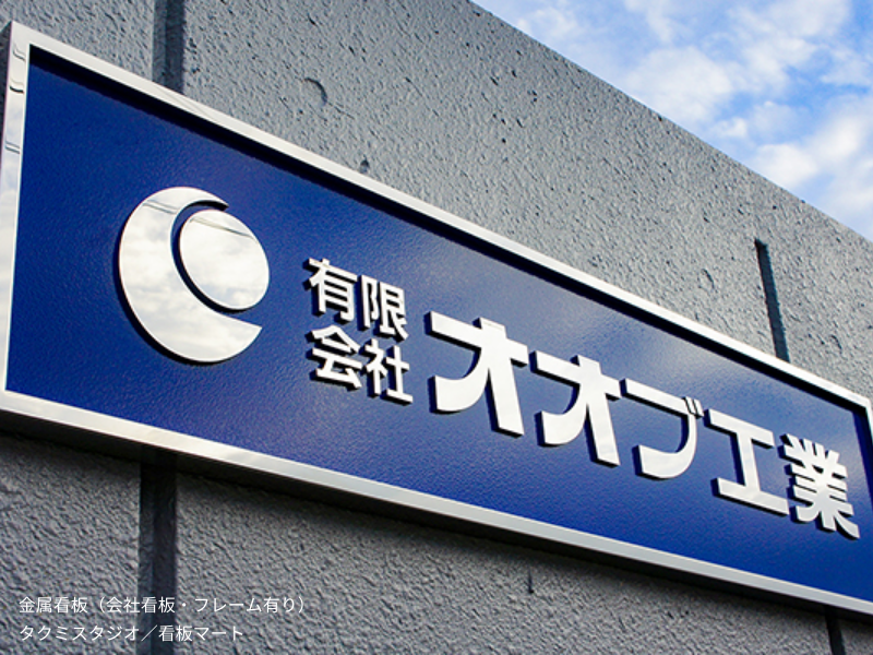 切文字タイプの金属看板（フレーム付き）。立体的な文字と枠で存在感を高めたデザイン。
