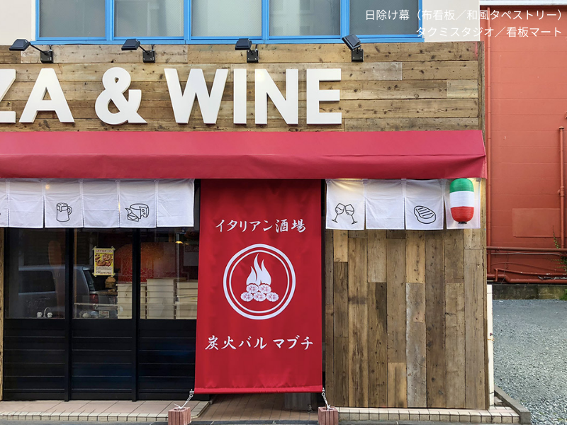 店舗の庇から地面に向かって設置された日除け幕。ブランドロゴ入りデザインで視認性と集客力を高める。