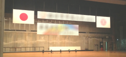 コンベンションホールのステージ背景に設置された仮設看板。短期イベントや講演に最適な大型サイン。