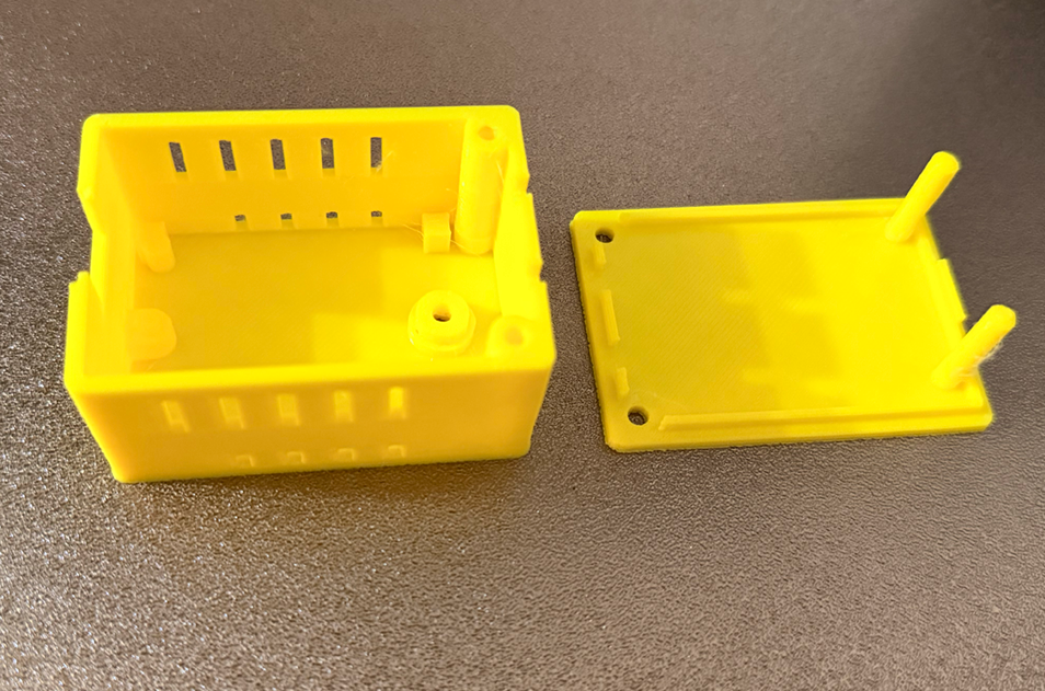 3D プリンターで印刷した黄色いケース本体とフタ