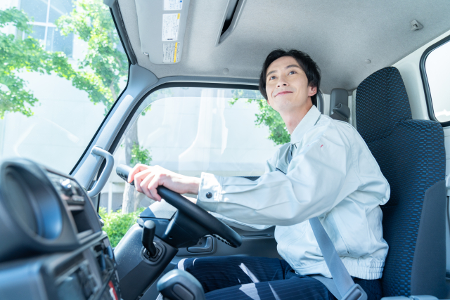 トラックを運転する若い男性
