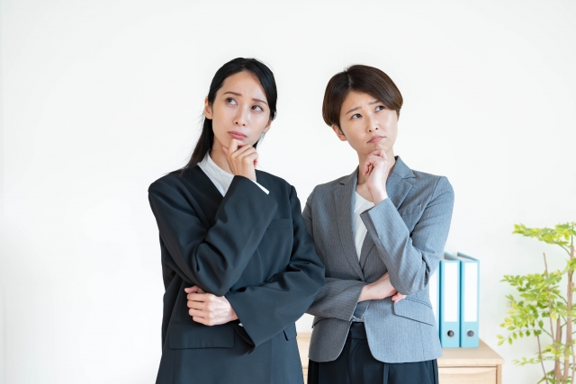 考えるスーツを着た女性二人
