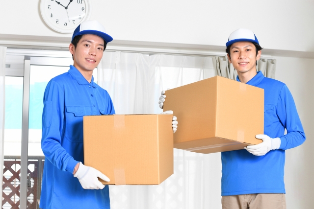 段ボールを持つ作業服を着た男性達