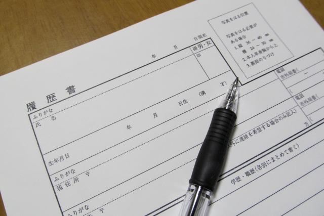 ボールペンと履歴書（顔写真貼付欄あり）