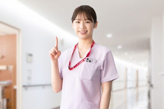 人差し指を立てて案内する女性医療スタッフ