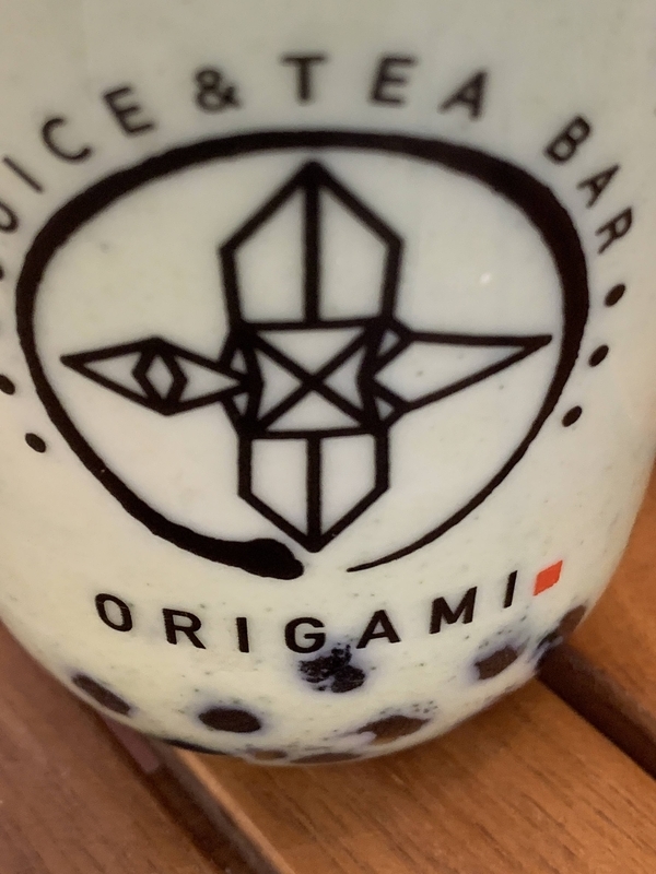 ORIGAMIのスタイリッシュなロゴが入ったドリンクカップ