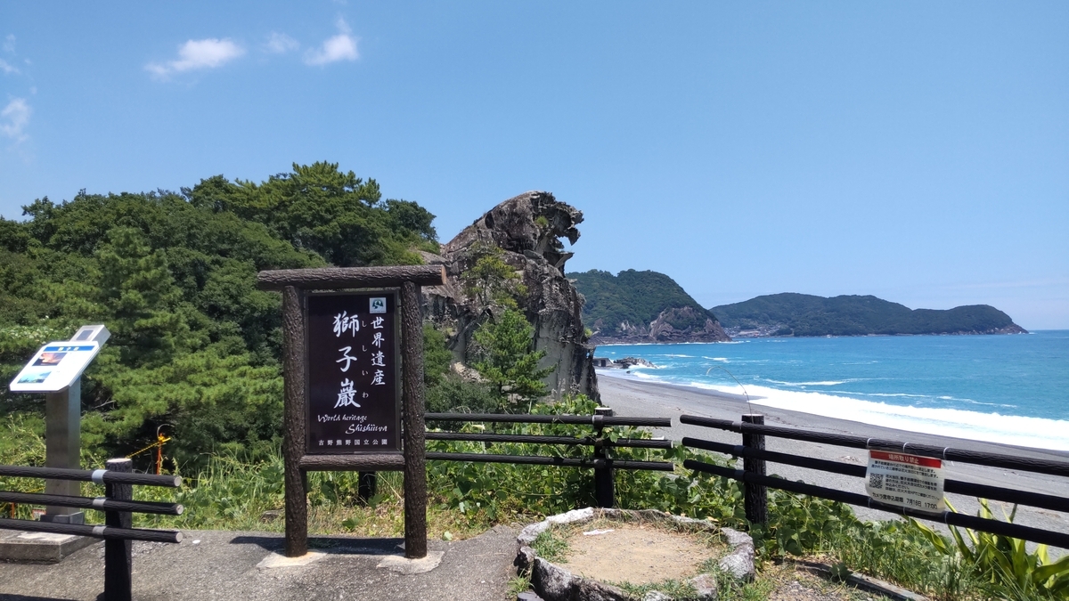 夏の七里御浜をバックに映える獅子巌と案内看板