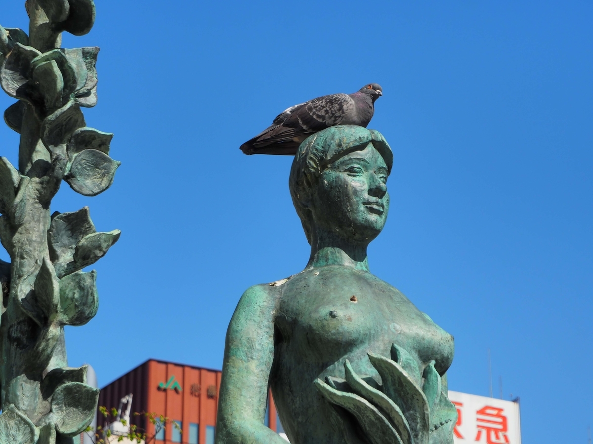 銅像の頭の上に鳩がとまっている