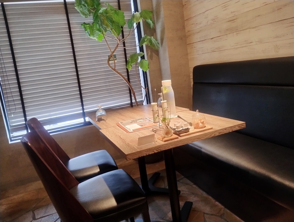 IVY’S PLACE cafeの店内。木目のテーブルに観葉植物が添えられ、落ち着いた雰囲気の4人席。