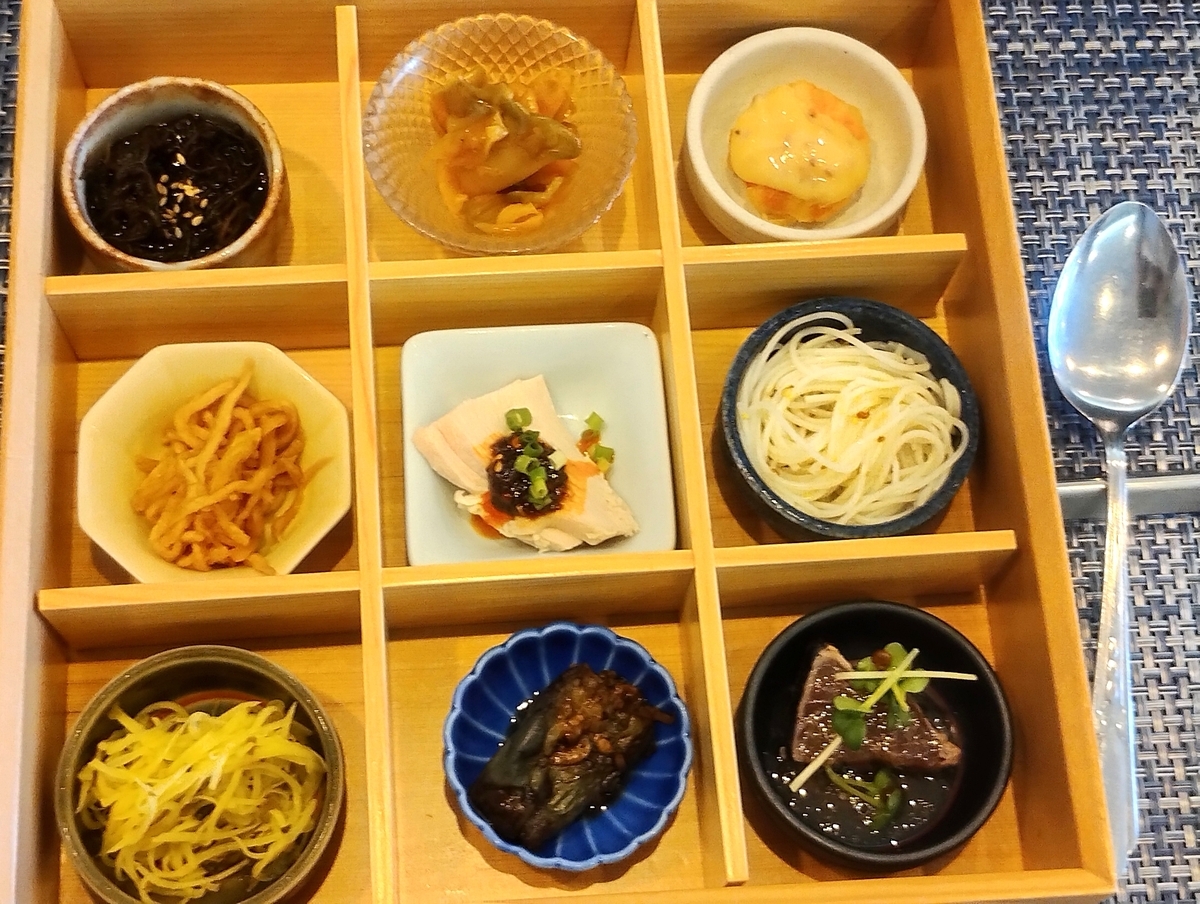 木箱の仕切りにそれぞれ盛り付けられた、9種類の小鉢の前菜