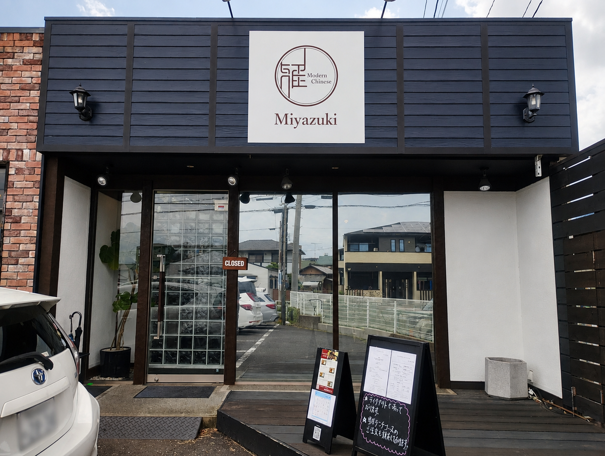 「Modern Chinese Miyazuki」の白い看板が掲げられた、黒と白のシックな建物の外観。ガラス張りの入り口前にはメニューが書かれた黒いスタンド看板が置かれている。