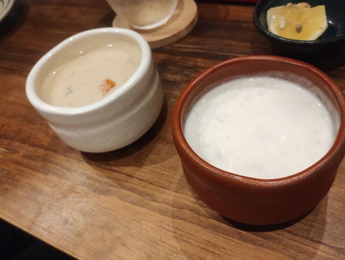 江南市のスペインバルKOMAで提供される本日のスープ2種。白い器にクラムチャウダー、茶色の器にかにとじゃがいもの冷製スープが盛られている