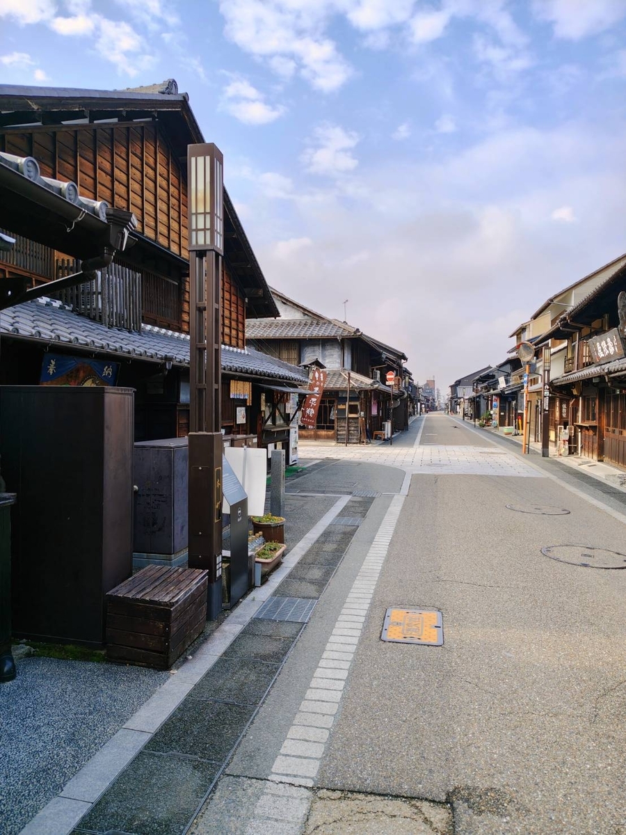 犬山城下町の通り。伝統的な木造家屋が並び、早朝の空が広がっている。