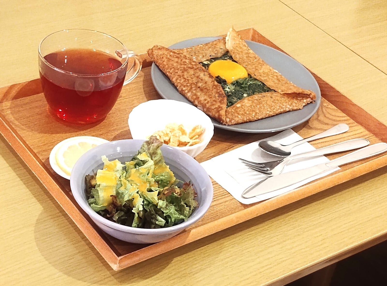ほうれん草と卵のガレットのランチセット。紅茶とサラダ付きの木のトレー