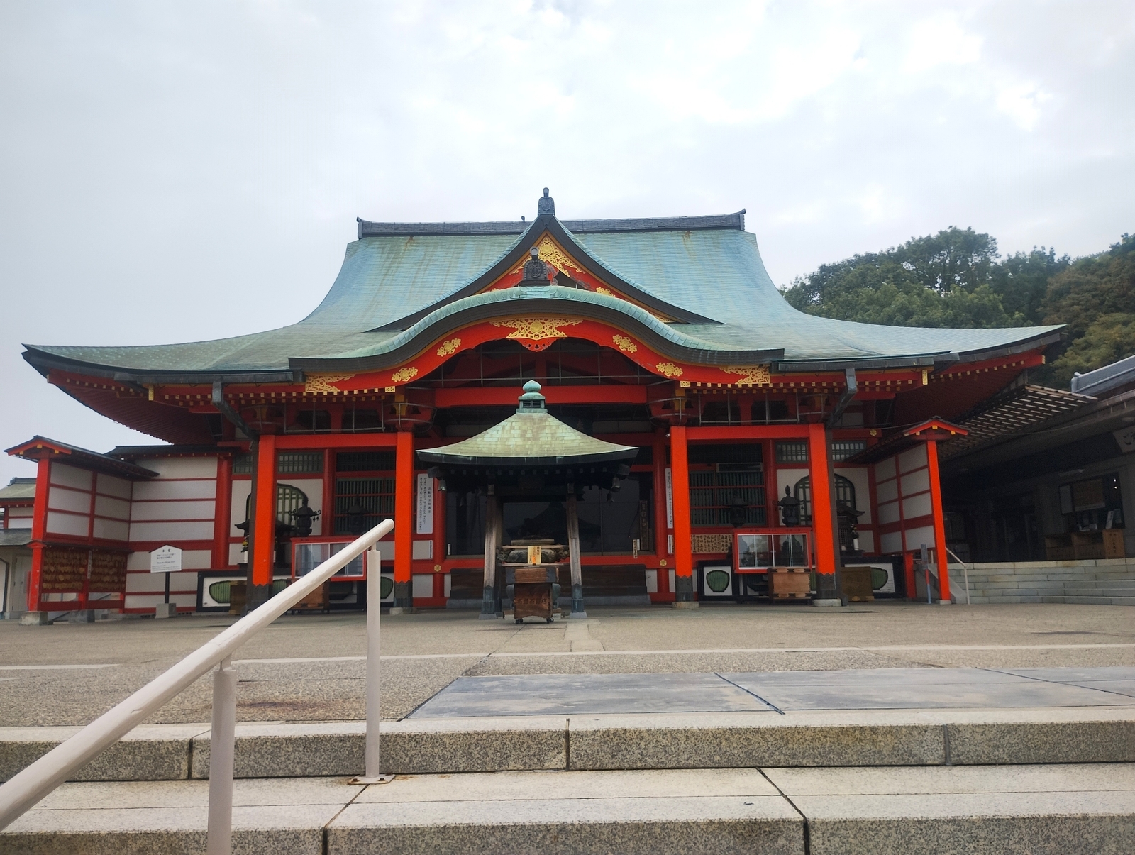 赤い柱と緑の屋根が特徴的な坂田山の神社本殿