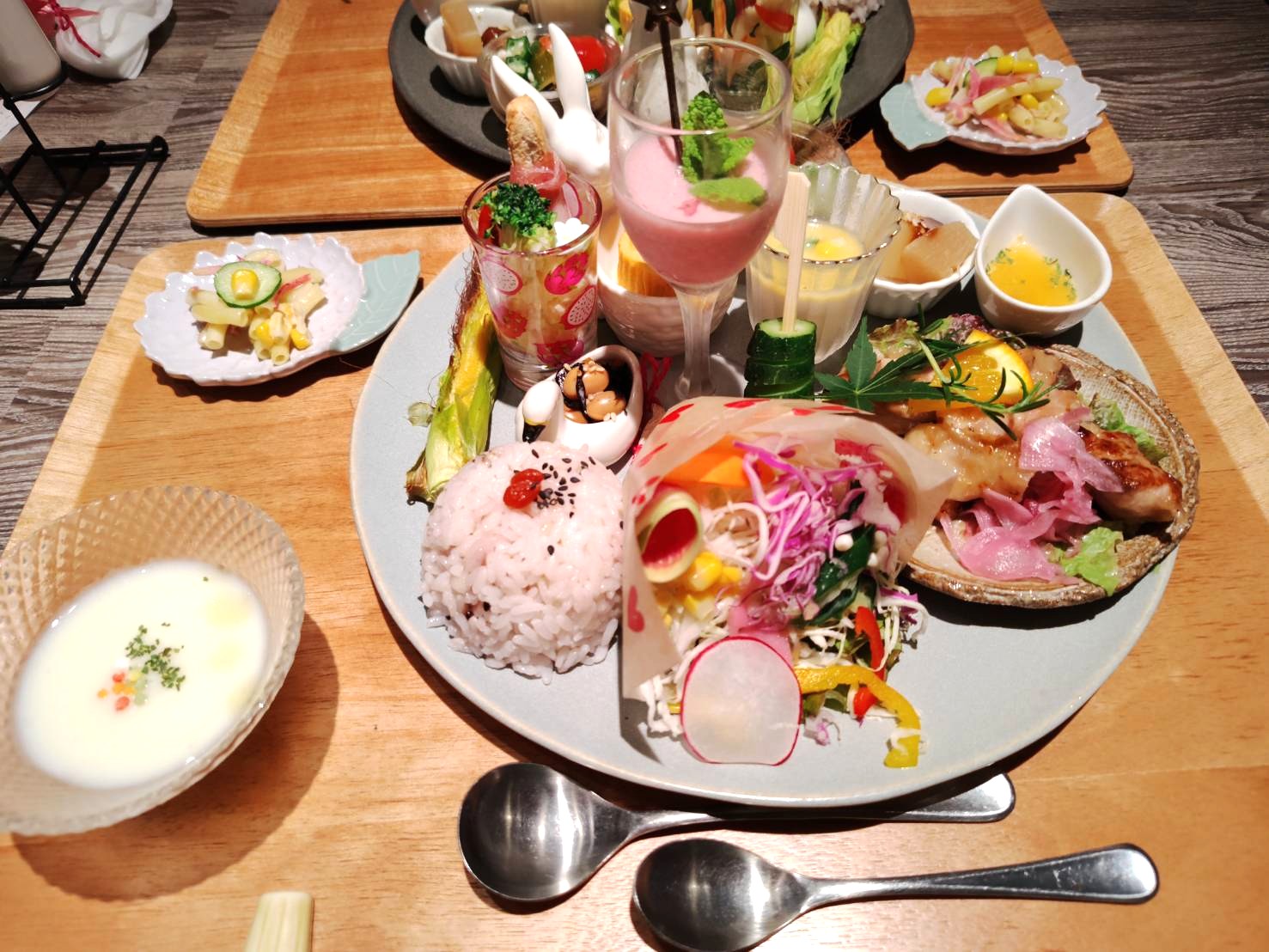 彩り豊かな和食ランチプレート。雑穀ご飯、サラダ、肉料理、スープ、デザートが木のトレーに並ぶ