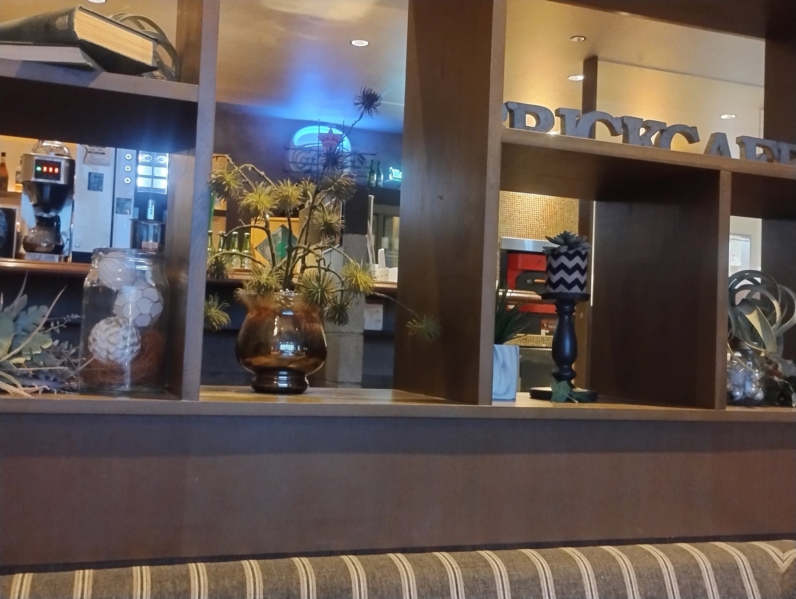 BRICK CAFE の店内にある木製の棚。雑貨や植物が飾られている。