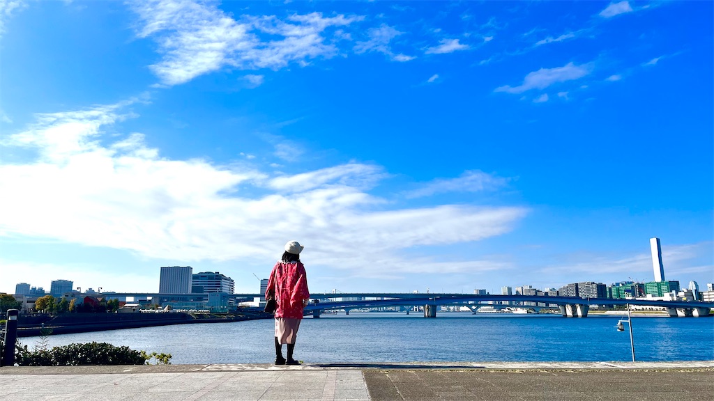 豊洲の海を眺める女性の背中が見えます。