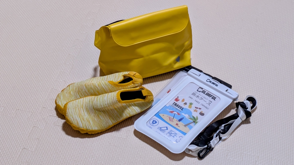 旅行で使った防水スマホケースとポーチとマリンシューズを並べた写真