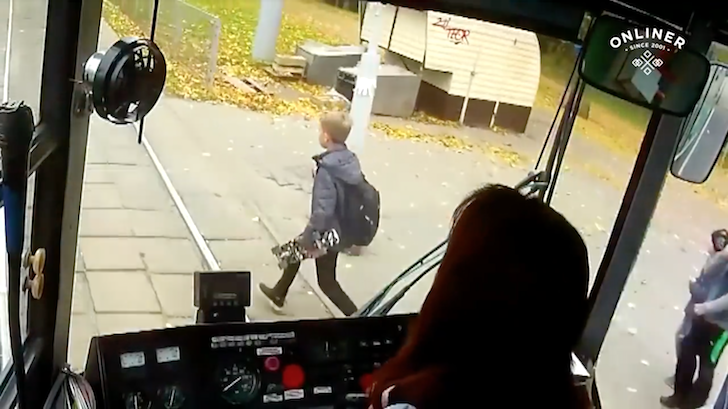 路面電車と接触しそうな少年