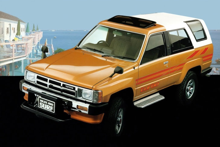 斜め前方から見ただいだい色の初代トヨタ・ハイラックスサーフ