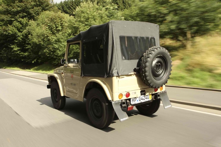 斜め後方から見た車道を走るスズキ・ジムニーSJ20型
