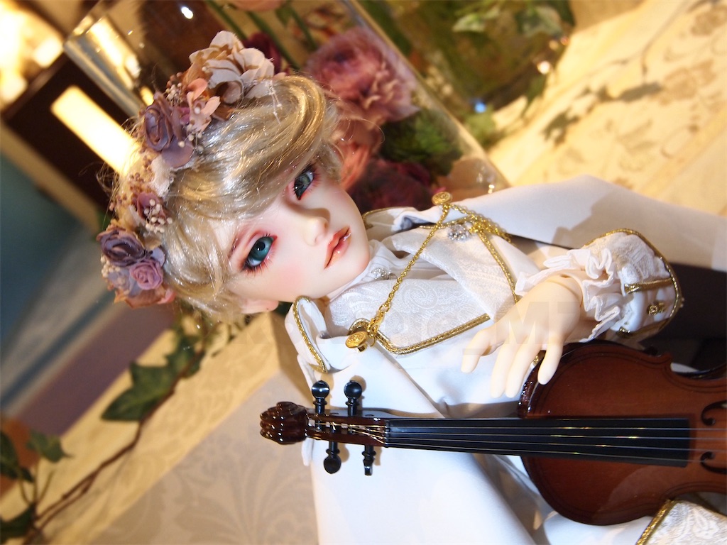 ラナンキュラスと共に写る王子様の恰好のつかさくんの写真。この頃は虹彩の大きいグラスアイを着用している。