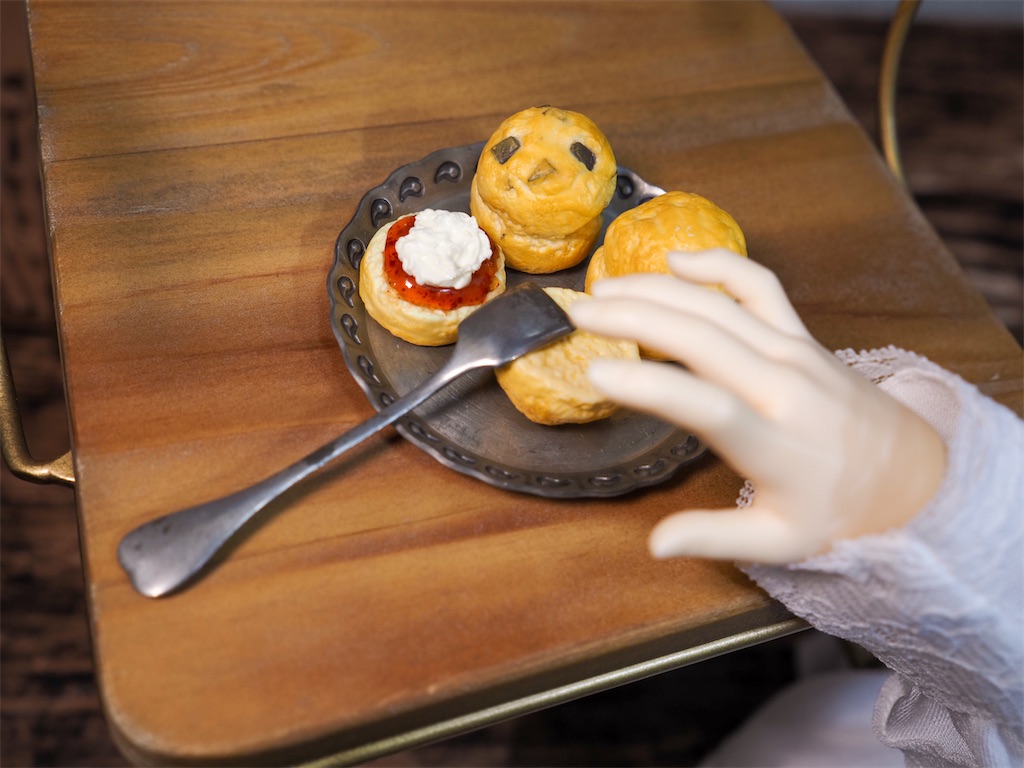 銀色のフランスアンティークの盆の上にスプーンとスコーンが載っている写真。