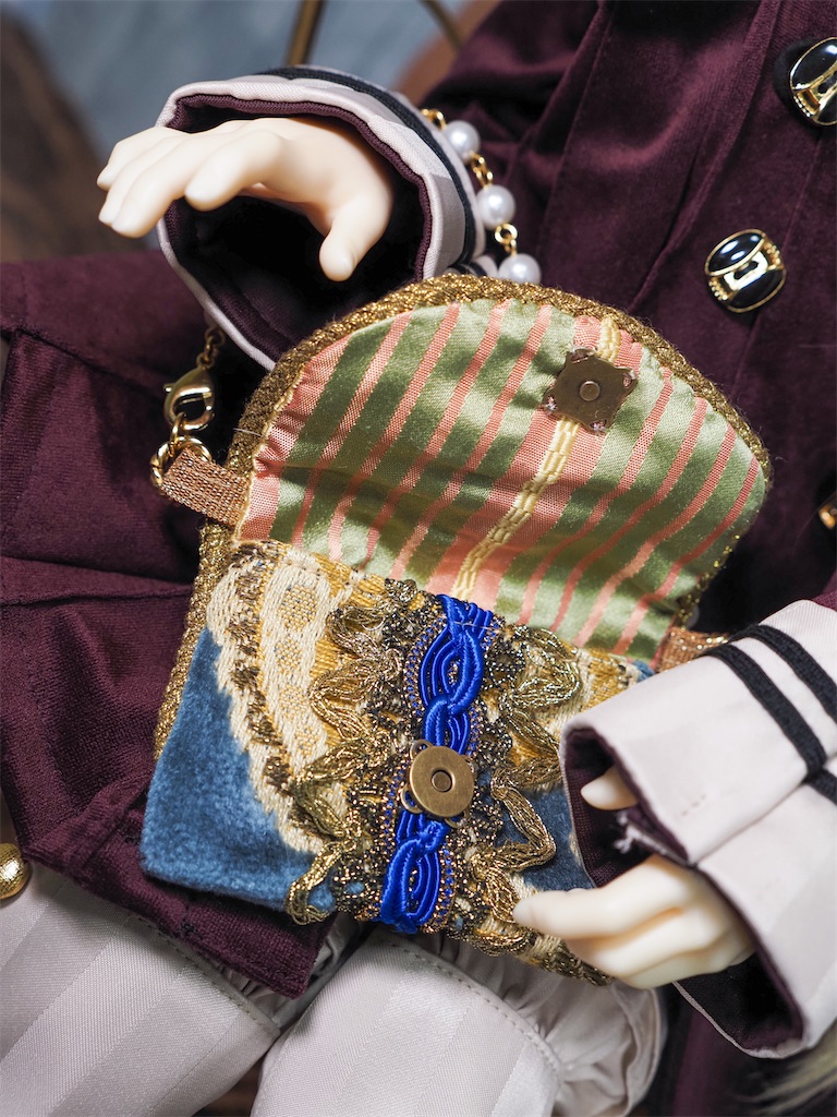 ドールサイズの鞄を開けた写真。裏地は緑とピンクのストライプ。