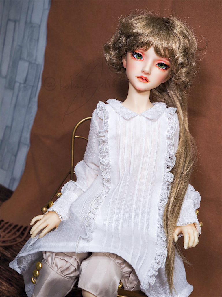 白いブラウスとベージュのストライプのクラシカルパンツを身につけたつかさくんの写真。