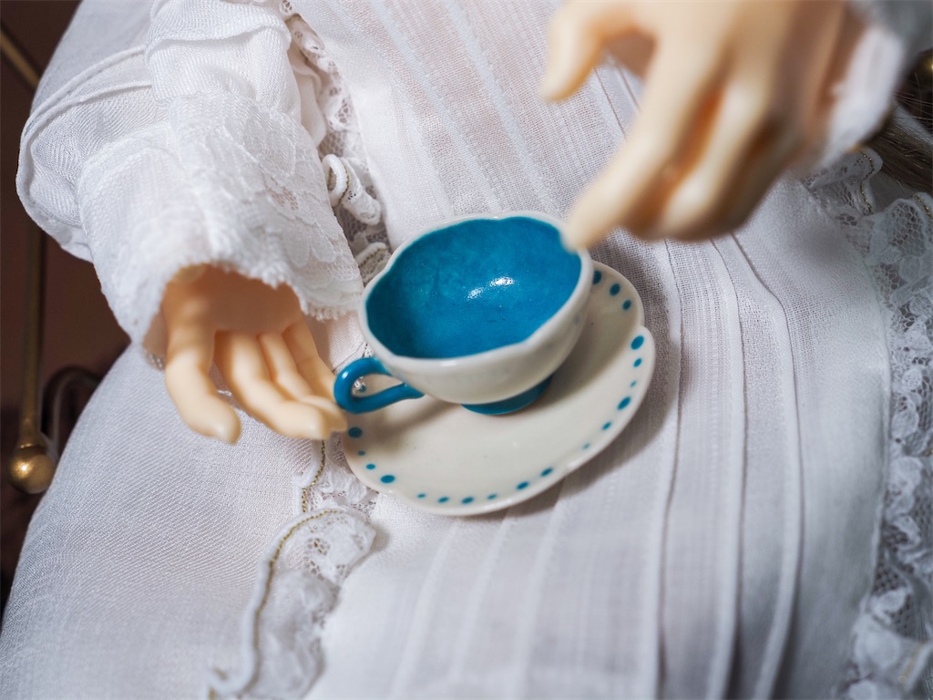 ドールサイズの水色と白の陶器のティーカップとソーサー。