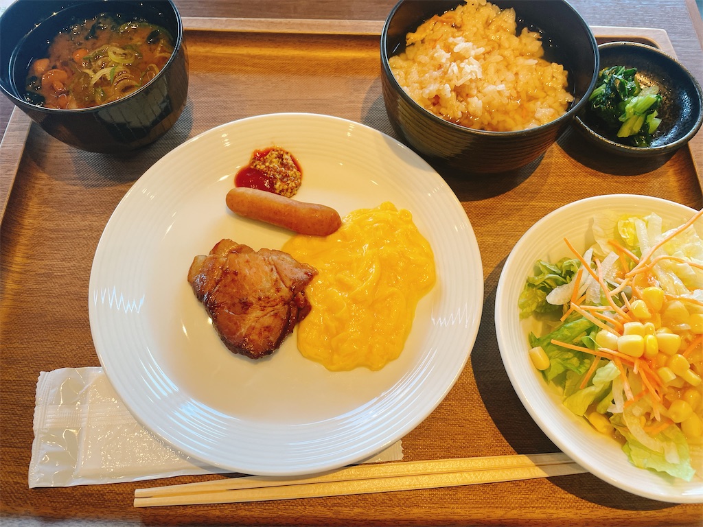 サラダ、スクランブルエッグ、味噌汁、お茶漬けがトレイの上に盛られている写真。