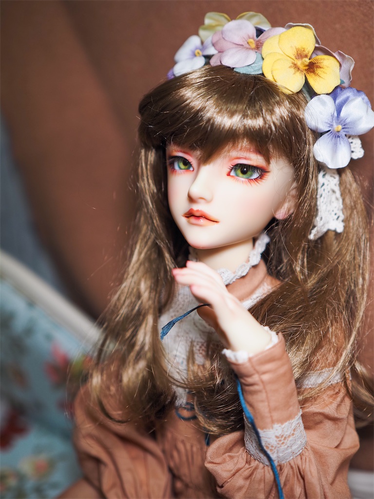 黄色や紫のパンジーの髪飾りを着けてテラコッタオレンジのドレスを着たつかさくんの写真。
