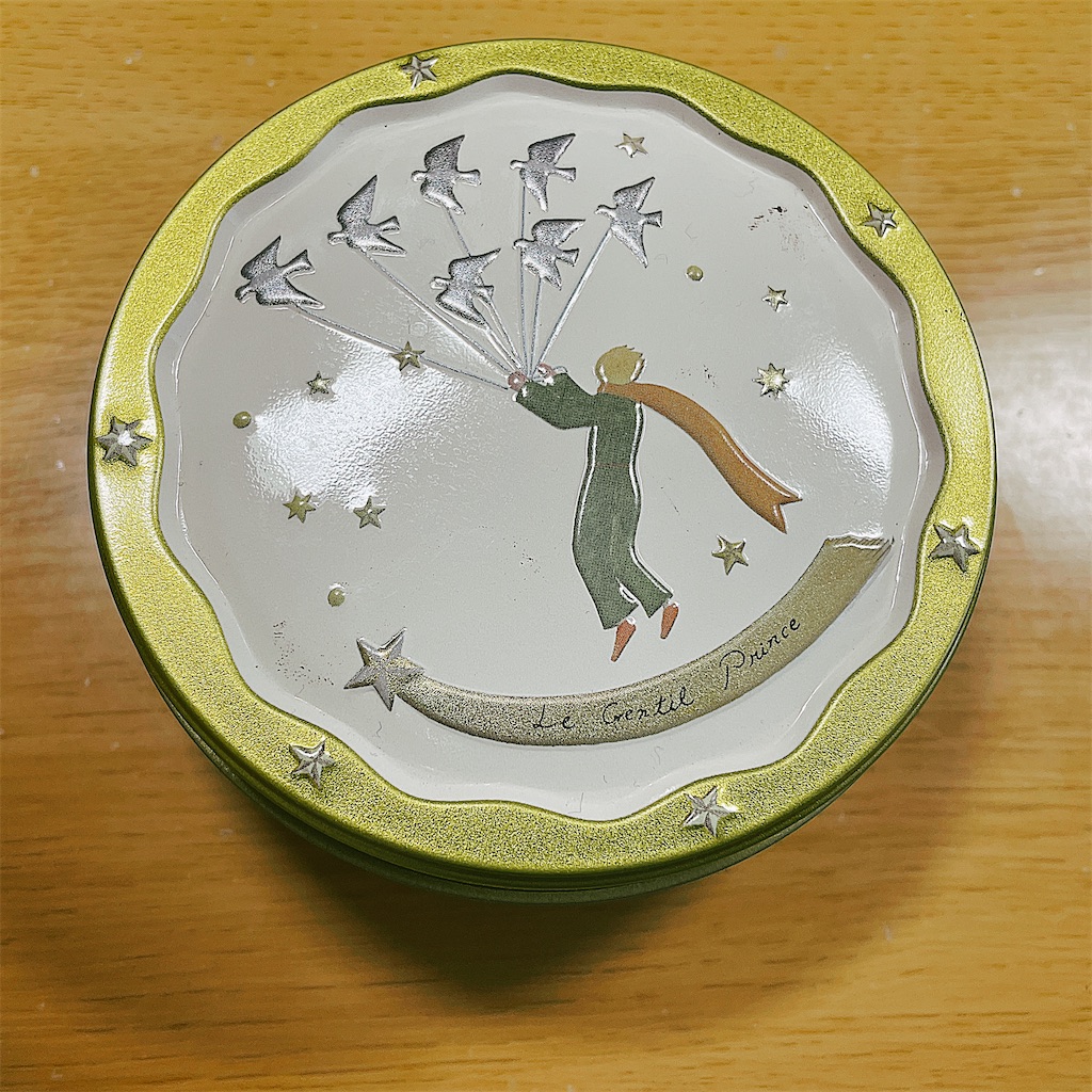 星の王子さまの絵が描かれたお菓子の缶の写真。