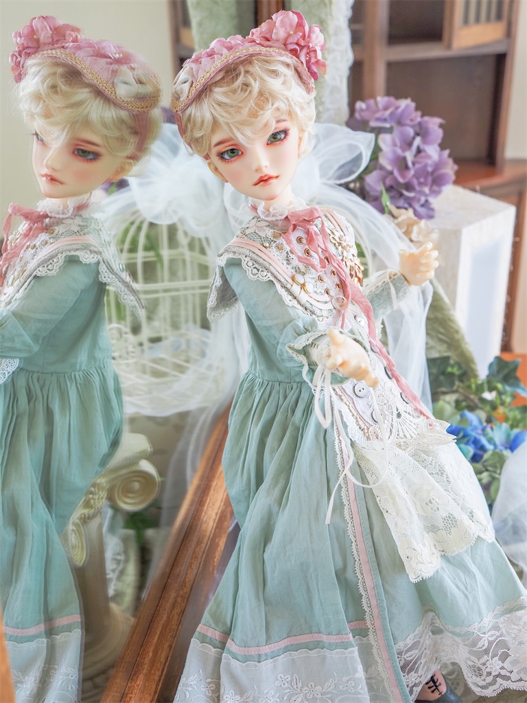 ミントグリーンとホワイトの中にピンクの差し色を組み合わせたドレスを着たつかさくんの写真。ピンクの紫陽花のヘッドドレスを着けている。