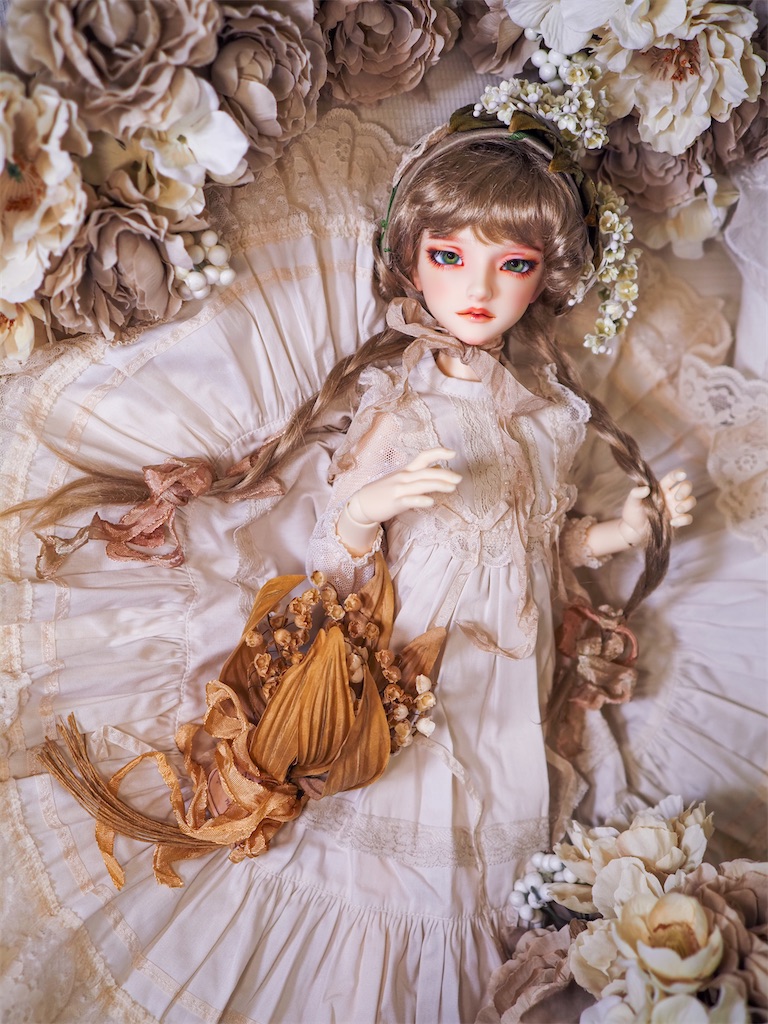 アイボリーのドレスに鈴蘭の布花のヘッドドレスを合わせたつかさくんの写真。