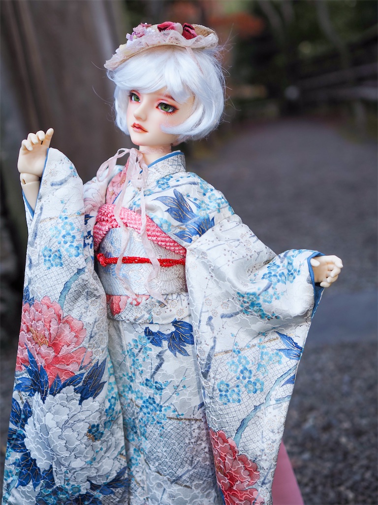 牡丹の振袖にピンクの小さな帽子のヘッドドレスを合わせたつかさくんの写真。
