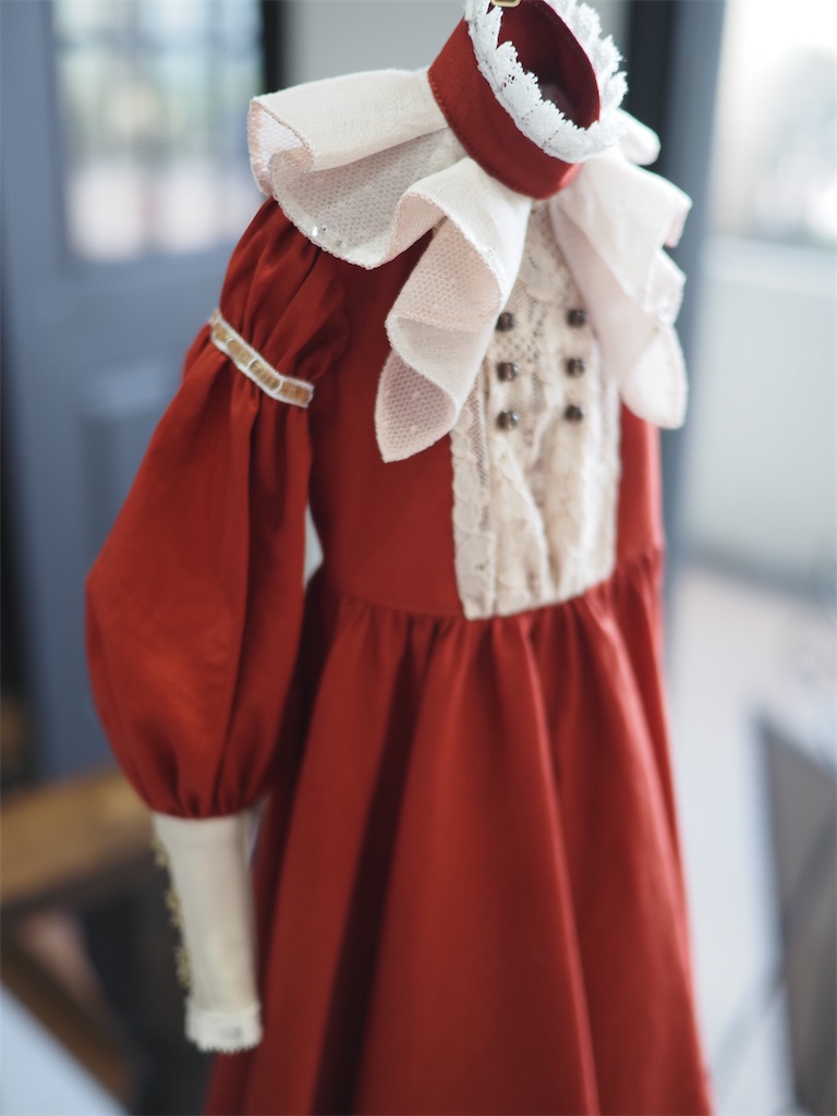 Ruffle dressの写真。赤いローン生地のドレスで襟元のラッフルフリルが特徴的。