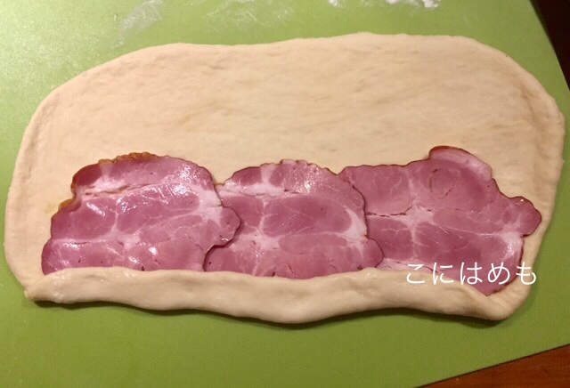 下のパン生地をハムにかぶさるように折りたたむ。